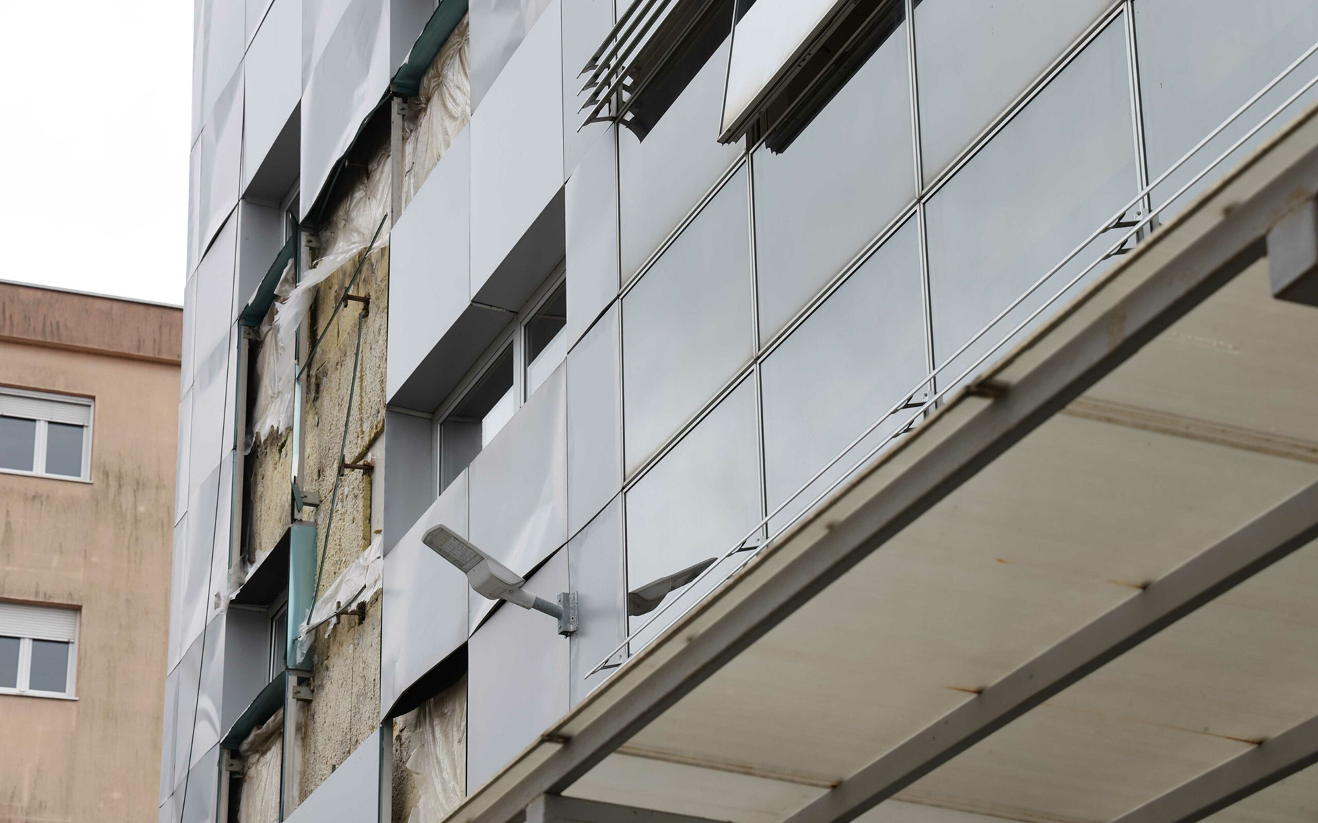 Facciata ventilata danneggiata e isolamento esposto, esempio di degrado dell’involucro edilizio per mancanza di protezione e manutenzione