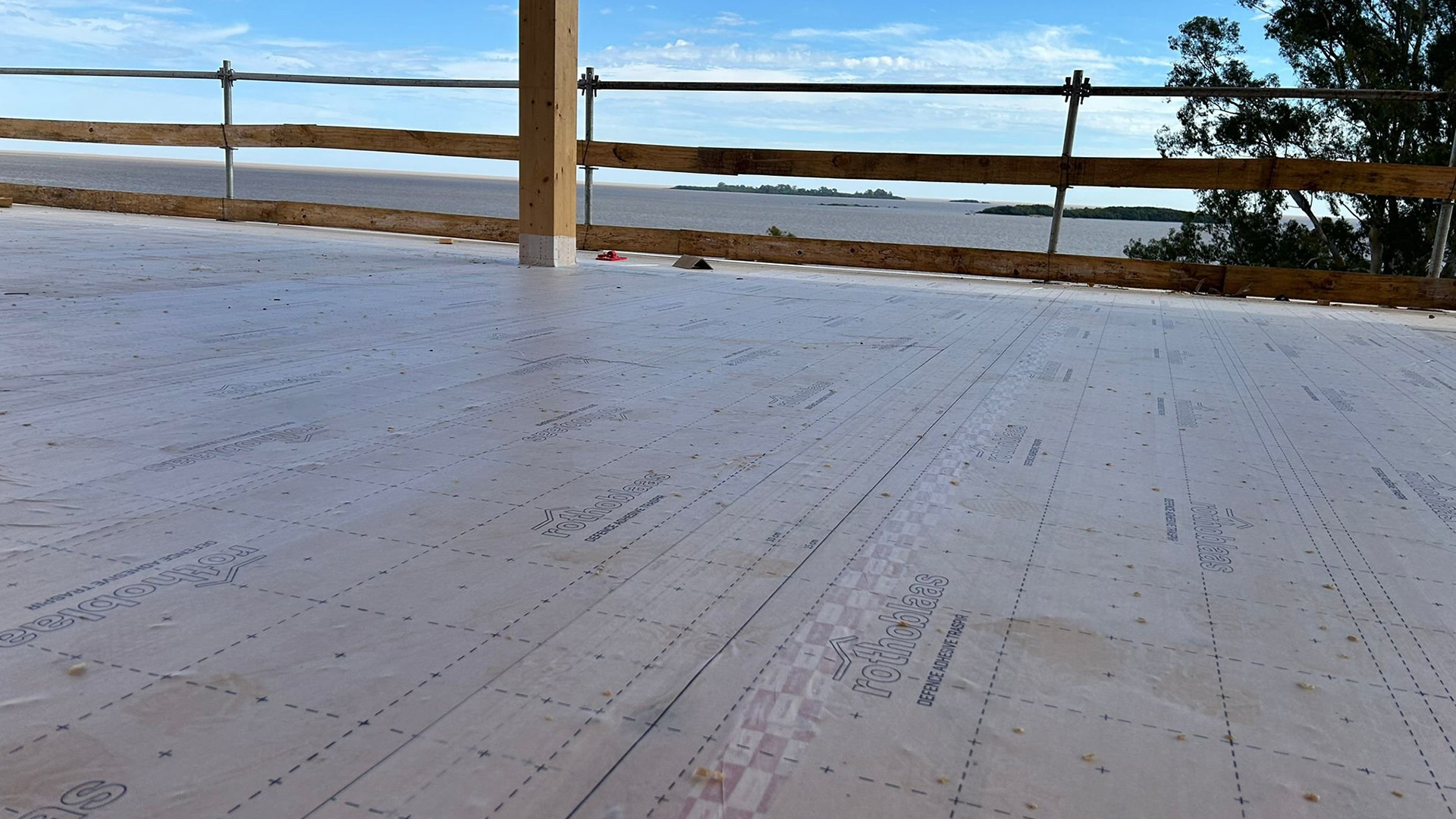 Self-adhesive membrane installed on timber floor slab during construction overlooking Río de la Plata