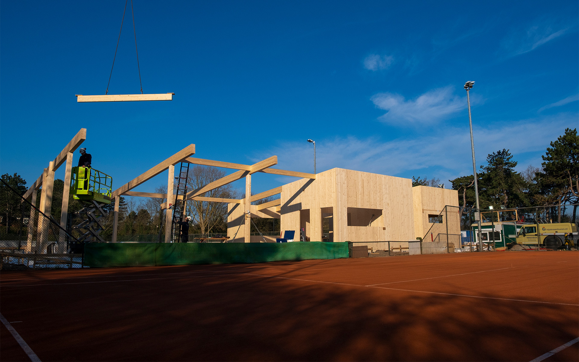 Timber pavilion construction with glulam beams and CLT structure at tennis club site